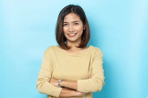 An image of a women with shoulder-length brunette hair wearing a light yellow sweatshirt smiling.  The background is light blue.  The woman is not a complete representation of the person writing the testimonial.